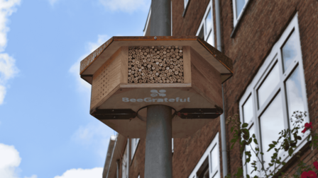 Groot bijenhotel dat hangt aan een lantaarnpaal