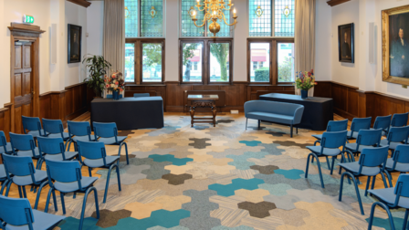 Interieur trouwzaal gemeentehuis met blauwe stoelen en een blauw bankje voor het bruidspaar