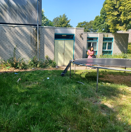 buitenkant gebouw De Meerklank: gras met trampoline