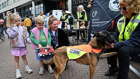 Kinderen maken kennis met een inzetreddingshond op het Emmaplein van Zeist.