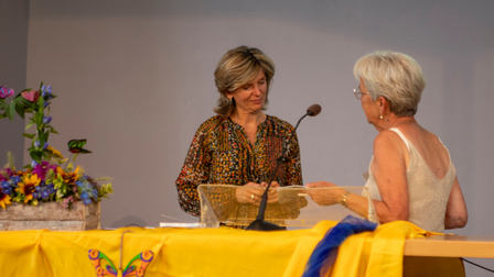 Fia Oomen overhandigt het boek De Schoonheid van de Troost aan de burgemeester.